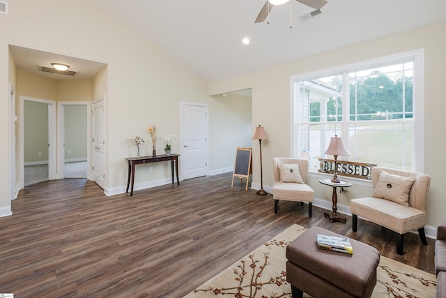 living area with ceiling fan, dark hardwood / wood-style floors, and lofted ceiling