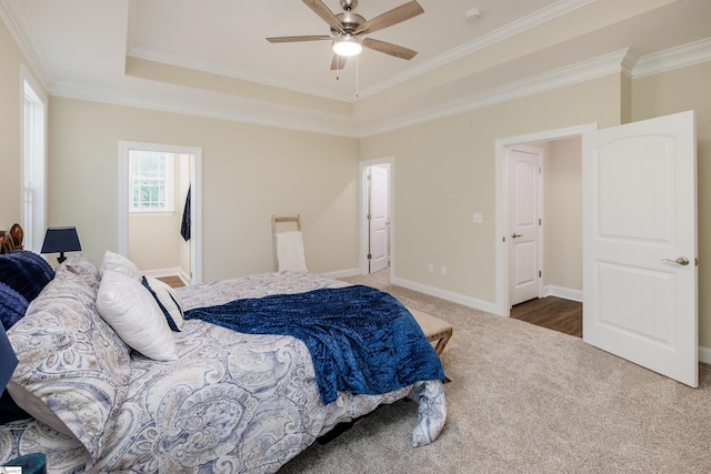 bedroom featuring ceiling fan, crown molding, a raised ceiling, and multiple windows