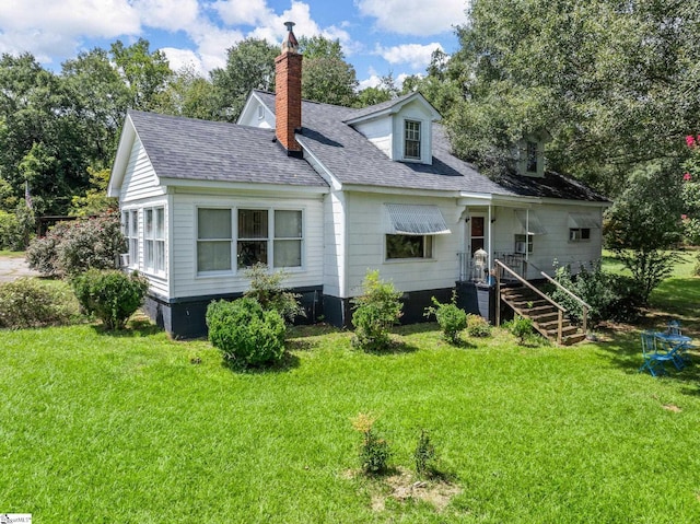 rear view of house featuring a yard