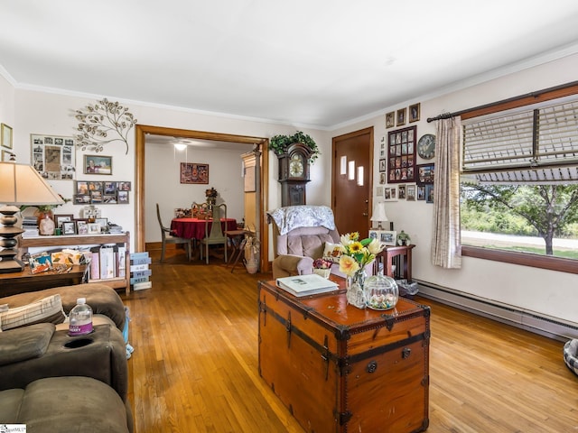 living room featuring a baseboard heating unit, crown molding, and light hardwood / wood-style floors