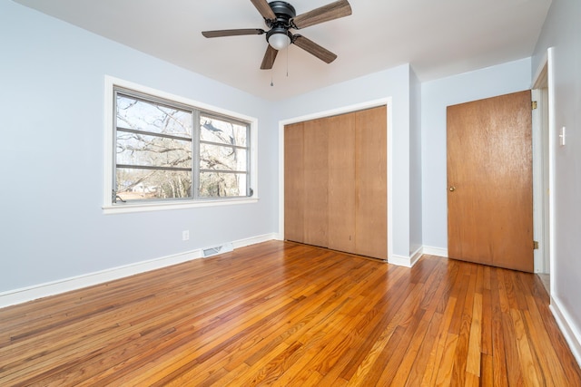 unfurnished bedroom with ceiling fan, a closet, and light hardwood / wood-style floors