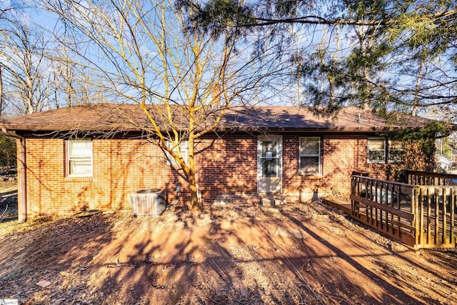 back of property with a wooden deck and cooling unit