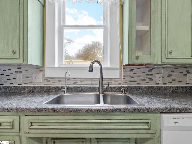 kitchen featuring green cabinets, white dishwasher, and sink