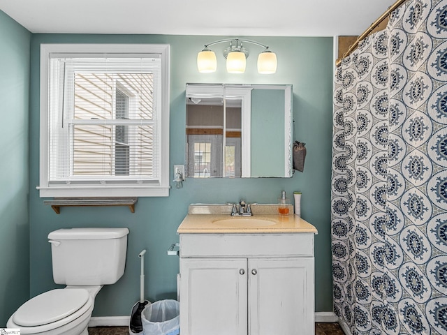 bathroom featuring toilet, a shower with shower curtain, and vanity