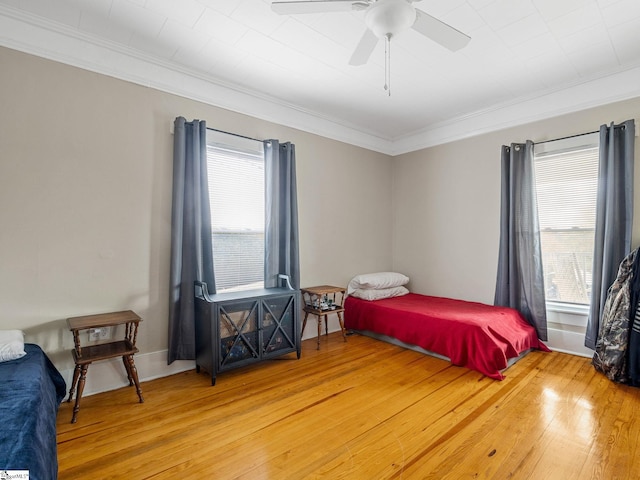 bedroom with ceiling fan, crown molding, and hardwood / wood-style flooring