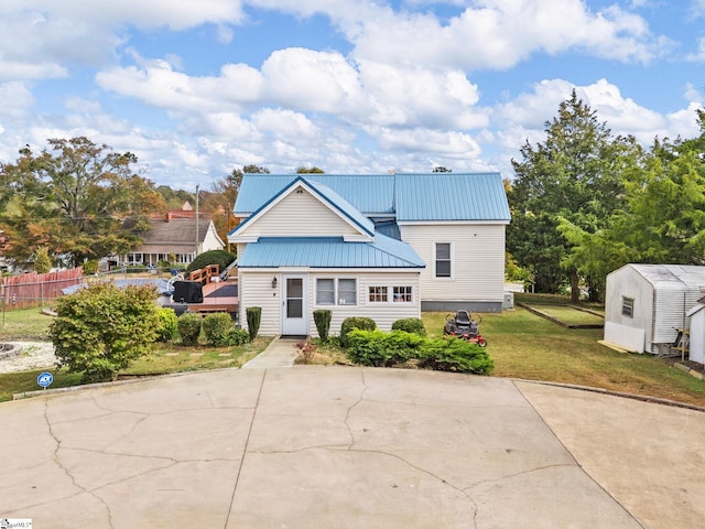 view of front of house featuring a front lawn and a storage unit