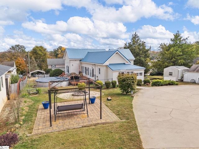 view of front facade with a shed, a gazebo, a front lawn, and a patio