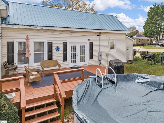 rear view of property featuring a deck and french doors