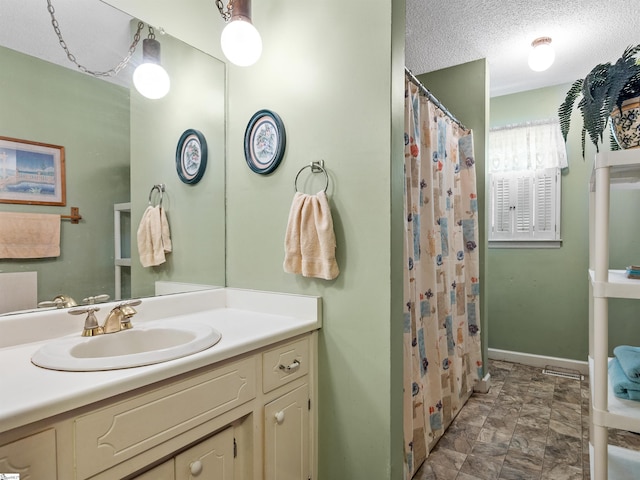 bathroom featuring vanity, a textured ceiling, and walk in shower