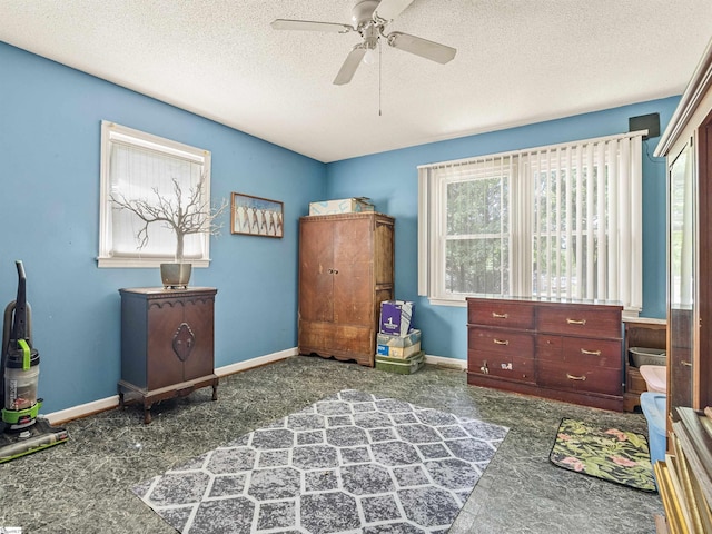 interior space featuring ceiling fan and a textured ceiling