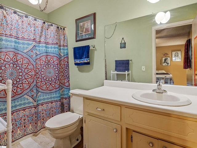 bathroom featuring vanity, a textured ceiling, and toilet