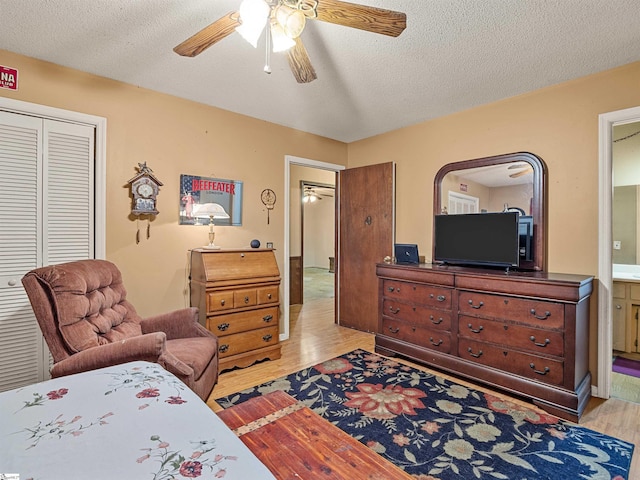 bedroom featuring ceiling fan, light hardwood / wood-style floors, a closet, and a textured ceiling