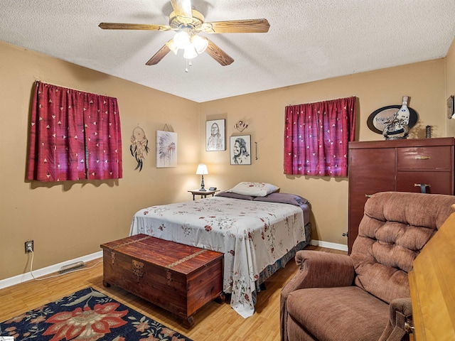 bedroom featuring ceiling fan, wood-type flooring, and a textured ceiling