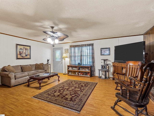 living room with hardwood / wood-style floors, ornamental molding, a textured ceiling, and ceiling fan