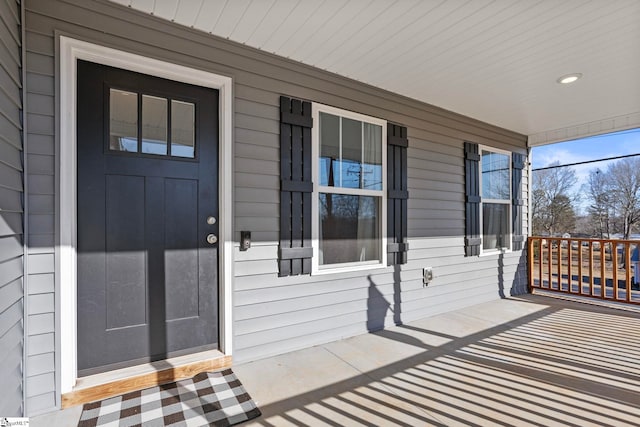 view of exterior entry featuring covered porch