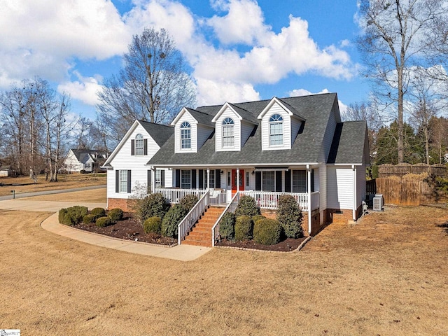 cape cod-style house featuring covered porch, cooling unit, and a front lawn