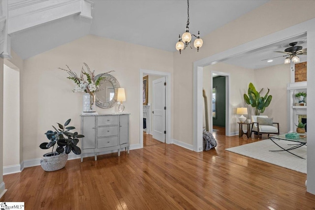 interior space featuring ceiling fan with notable chandelier and hardwood / wood-style flooring