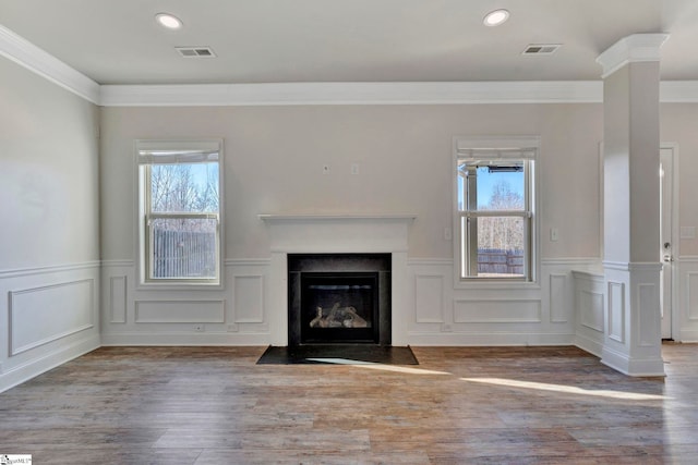 unfurnished living room featuring crown molding, a healthy amount of sunlight, and a premium fireplace