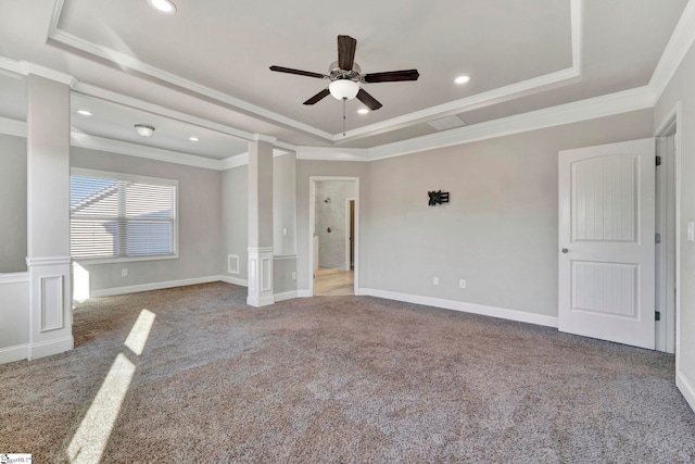 carpeted spare room with crown molding, ceiling fan, a tray ceiling, and ornate columns