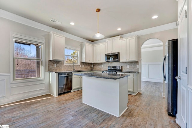 kitchen featuring crown molding, appliances with stainless steel finishes, hanging light fixtures, white cabinets, and a kitchen island