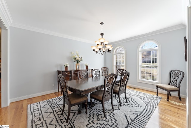 dining area with ornamental molding, a chandelier, and light wood-type flooring