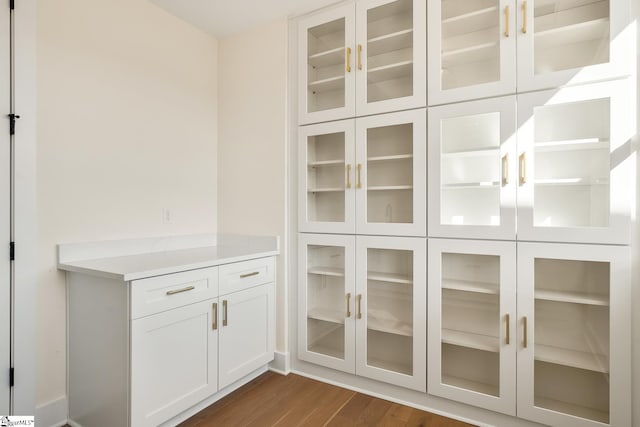 interior space with dark hardwood / wood-style floors and white cabinets