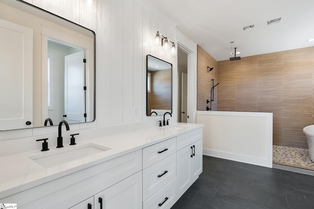 bathroom featuring vanity, tile patterned flooring, and tiled shower