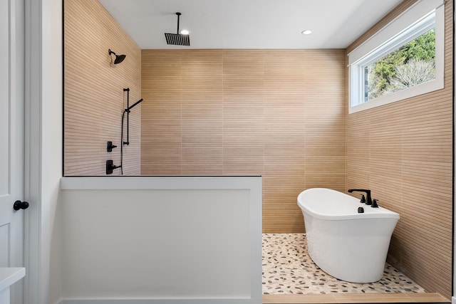 bathroom with tile walls and separate shower and tub