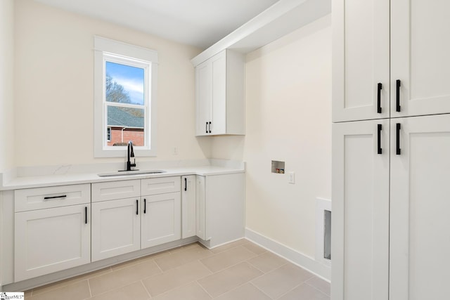 laundry area with washer hookup, cabinets, light tile patterned flooring, and sink