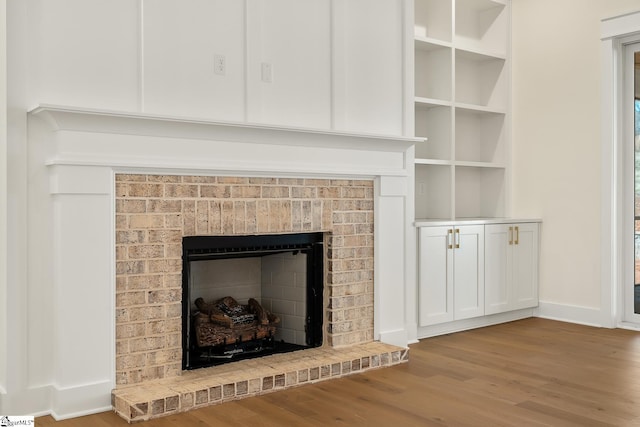 details featuring a brick fireplace and wood-type flooring