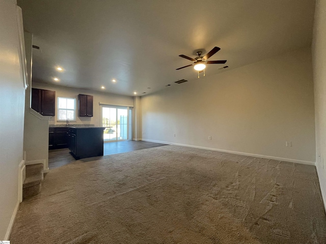 unfurnished living room with ceiling fan and carpet flooring