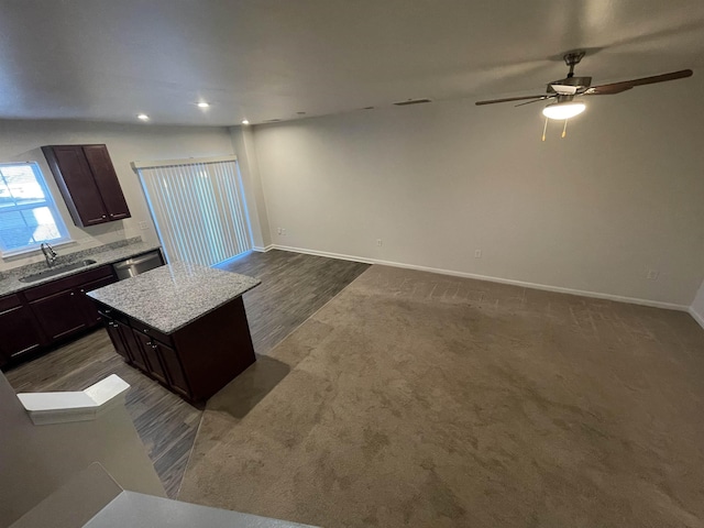 kitchen with ceiling fan, a kitchen island, stainless steel dishwasher, sink, and dark brown cabinetry