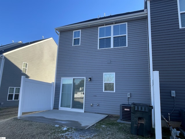 back of property with central AC and a patio