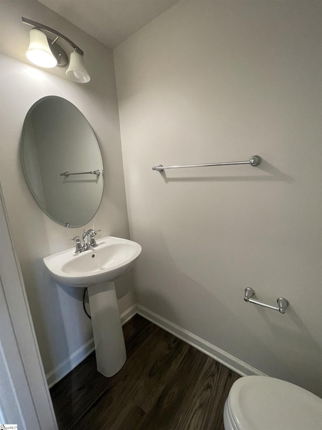 bathroom with toilet and hardwood / wood-style flooring