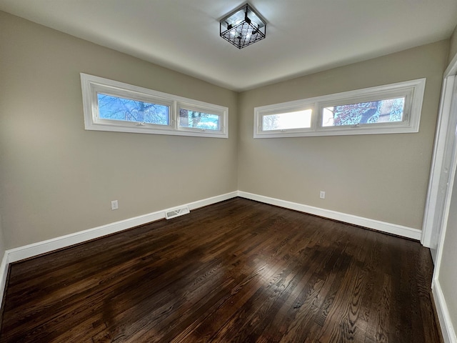 unfurnished room with dark wood-type flooring