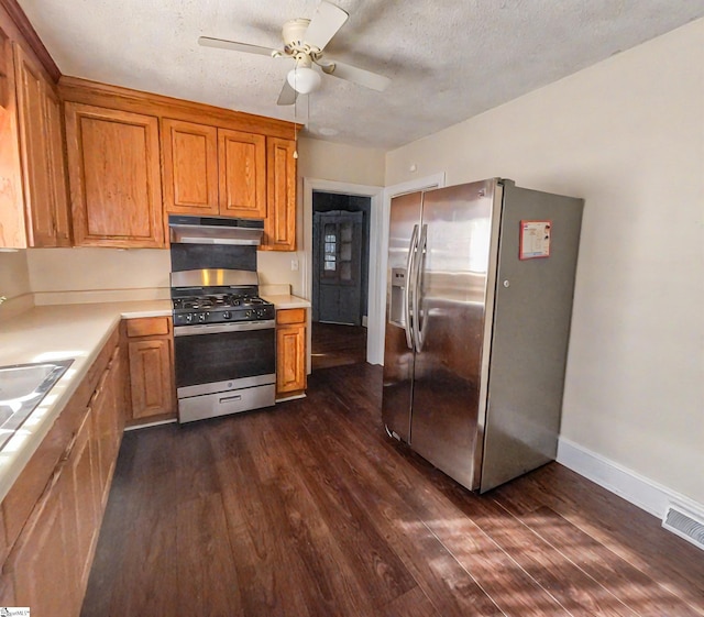 kitchen with a textured ceiling, ceiling fan, stainless steel appliances, and dark hardwood / wood-style flooring