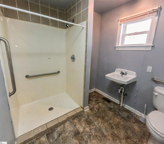 bathroom with toilet and tiled shower