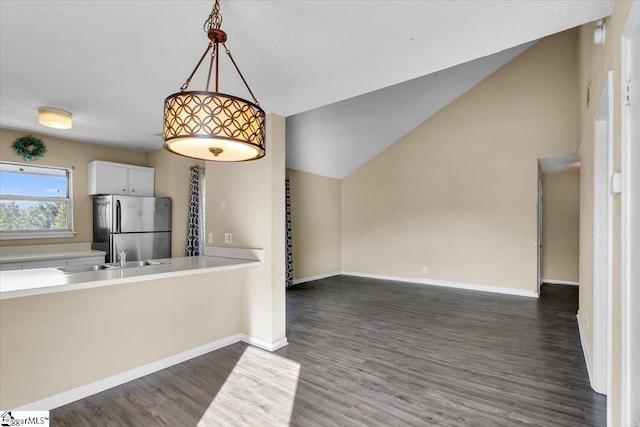 kitchen featuring decorative light fixtures, sink, dark wood-type flooring, white cabinets, and stainless steel fridge