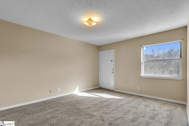 carpeted empty room with a textured ceiling