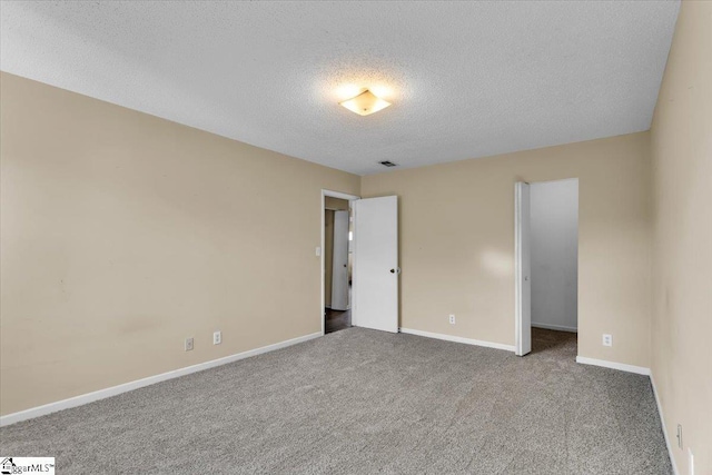 unfurnished bedroom with a textured ceiling and carpet flooring