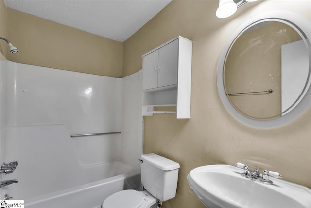 full bathroom featuring toilet, sink, a textured ceiling, and washtub / shower combination