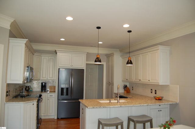 kitchen featuring stainless steel appliances, sink, backsplash, and decorative light fixtures