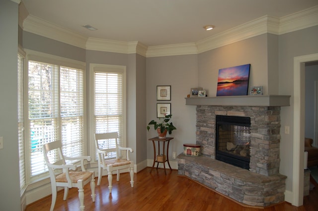 sitting room featuring a fireplace, ornamental molding, and hardwood / wood-style flooring