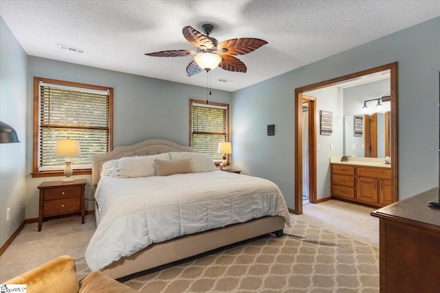 carpeted bedroom with a textured ceiling, ceiling fan, connected bathroom, and multiple windows