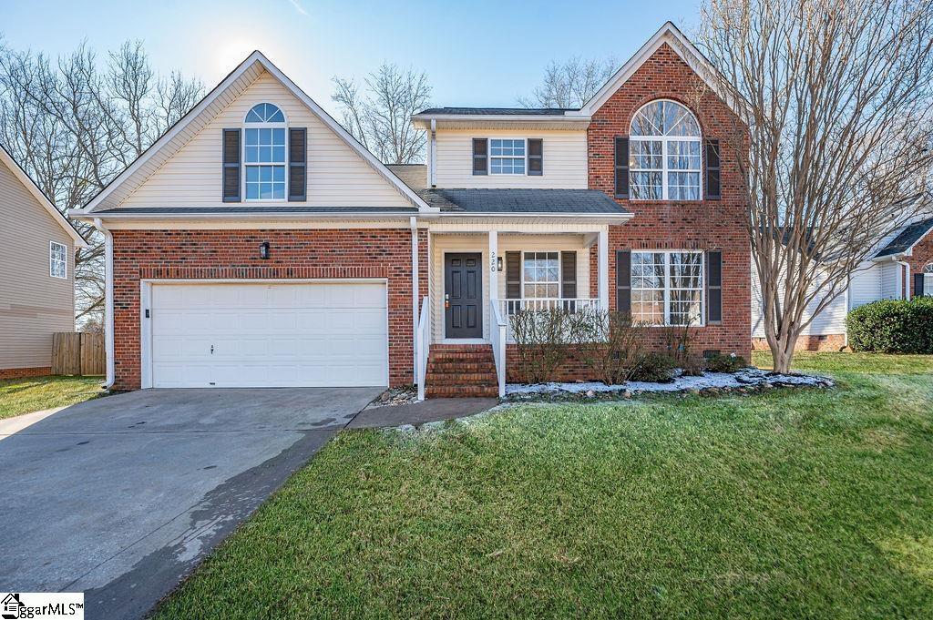 view of front property featuring a garage, a front lawn, and covered porch