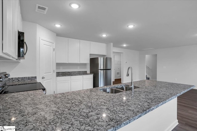 kitchen with white cabinets, stainless steel fridge, sink, and range with electric cooktop