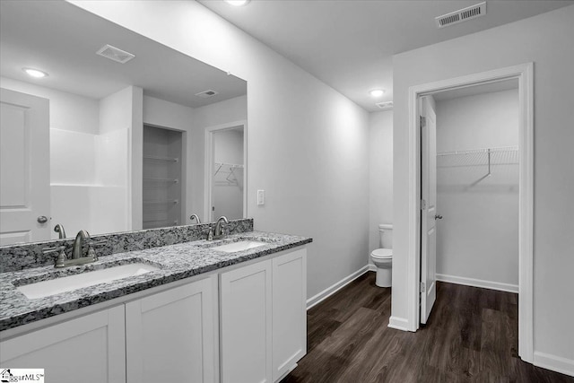 bathroom with toilet, vanity, and hardwood / wood-style floors