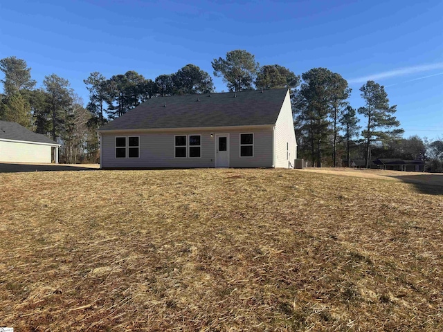 rear view of property featuring cooling unit and a yard