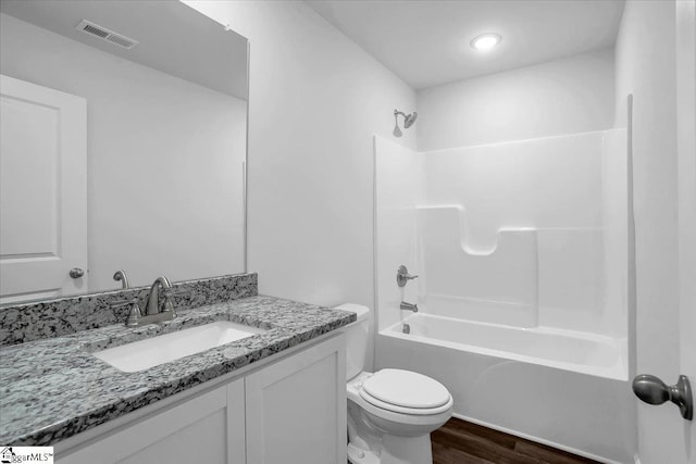 full bathroom featuring toilet, vanity, shower / washtub combination, and hardwood / wood-style floors