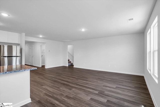 unfurnished living room with dark wood-type flooring